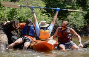 Taylor Morris and Chris Thompson lend a fellow paddler a lift over a cross-river strainer  during a grueling 17-mile paddle on day 2 of our journey. 